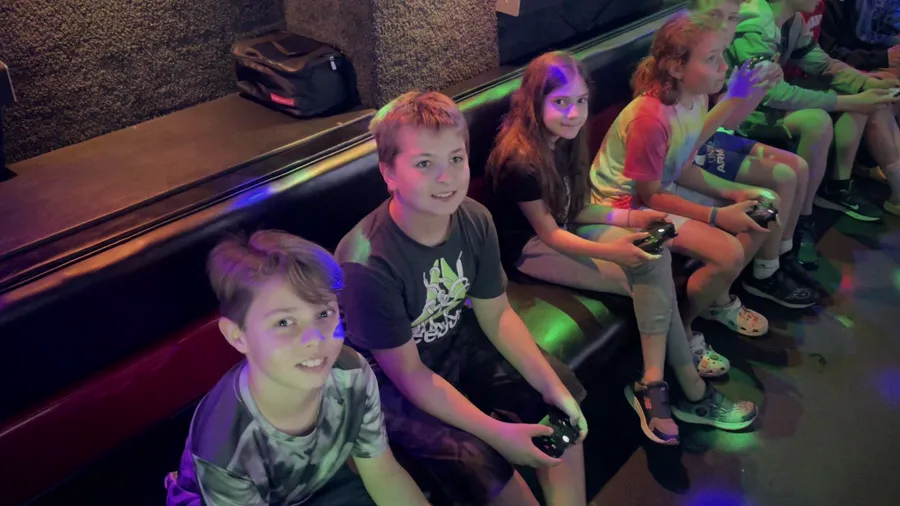 Kids smiling with controllers in the glowing game truck